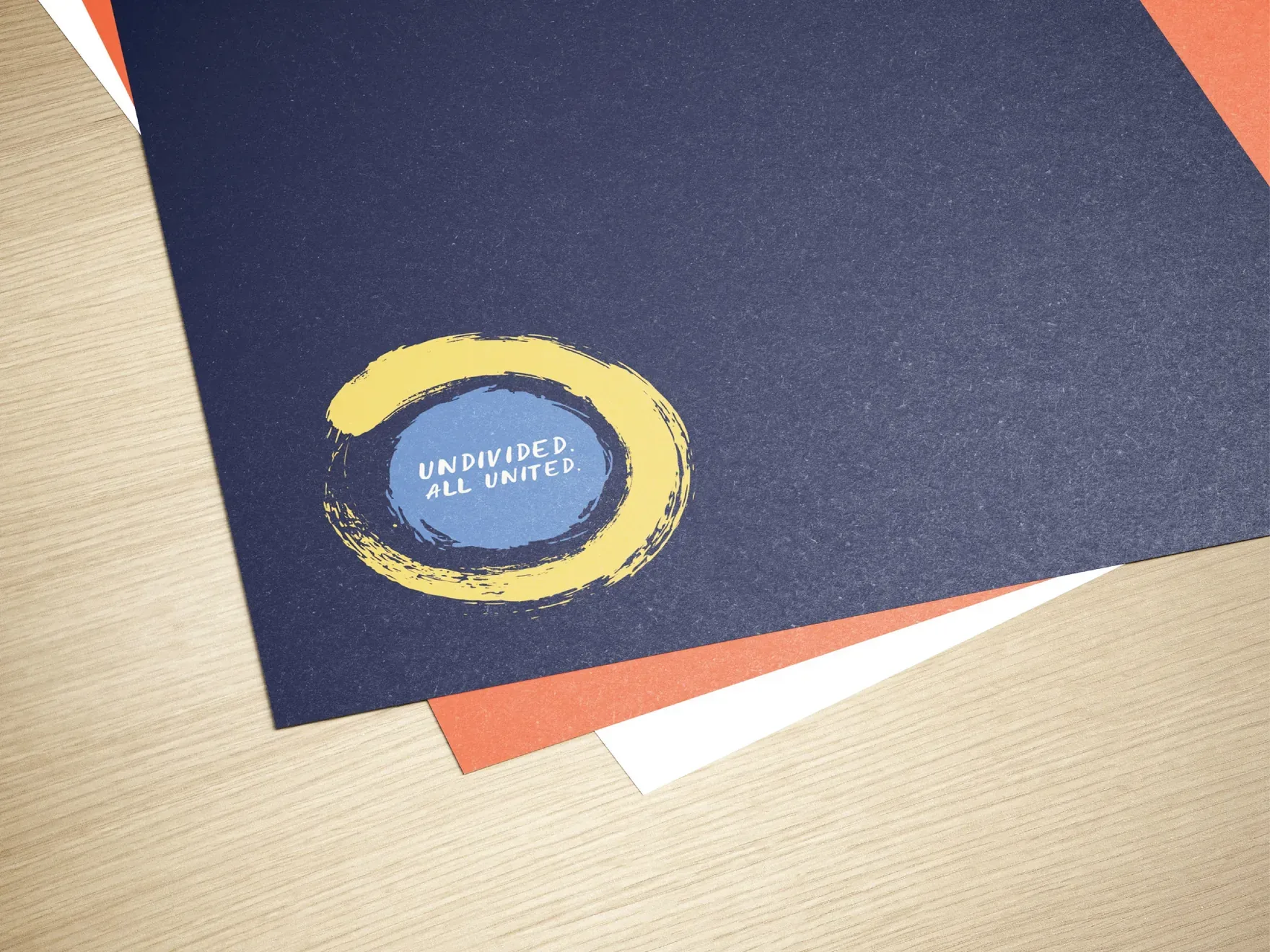 Navy, orange and white event folders with the circular Undivided. All United. mark.
