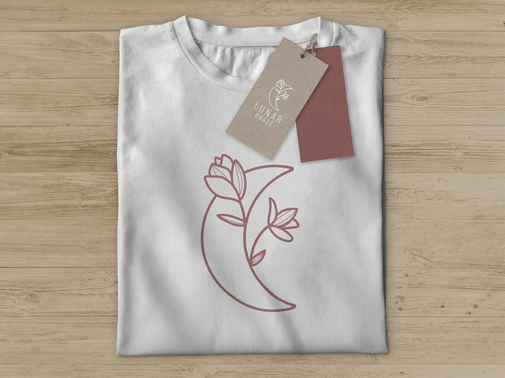 Folded white t-shirt with the mauve Lunar Grace line mark and a hang tag.