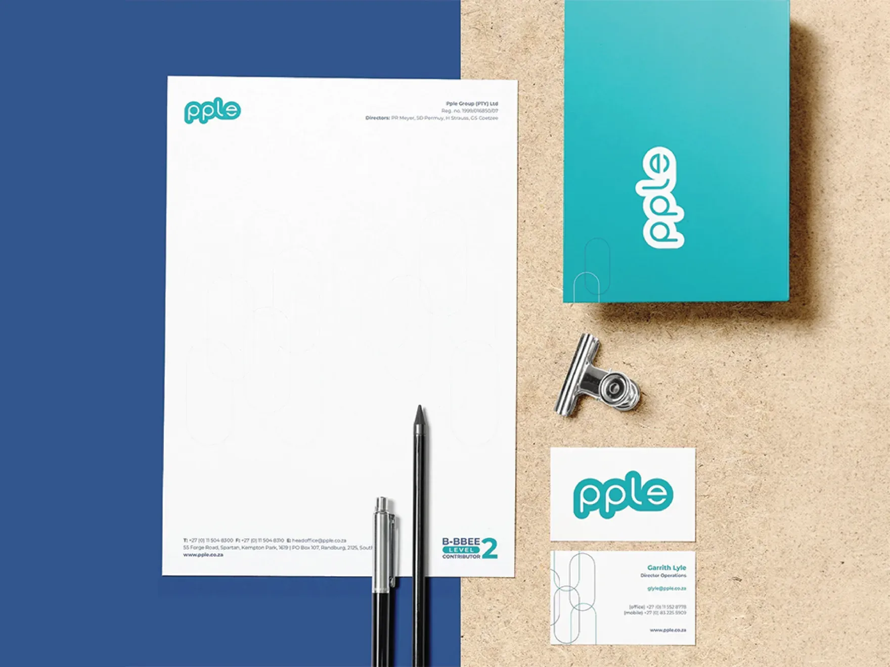 PPLE letterhead, business cards and a teal folder laid out on a navy and kraft background.